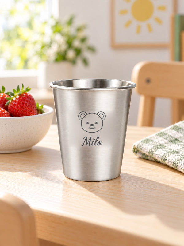 Visuel d’illustration – gobelet inox sur une table d’enfant près d’un bol de fraises, gravé d’un ourson et « Milo » (exemple)