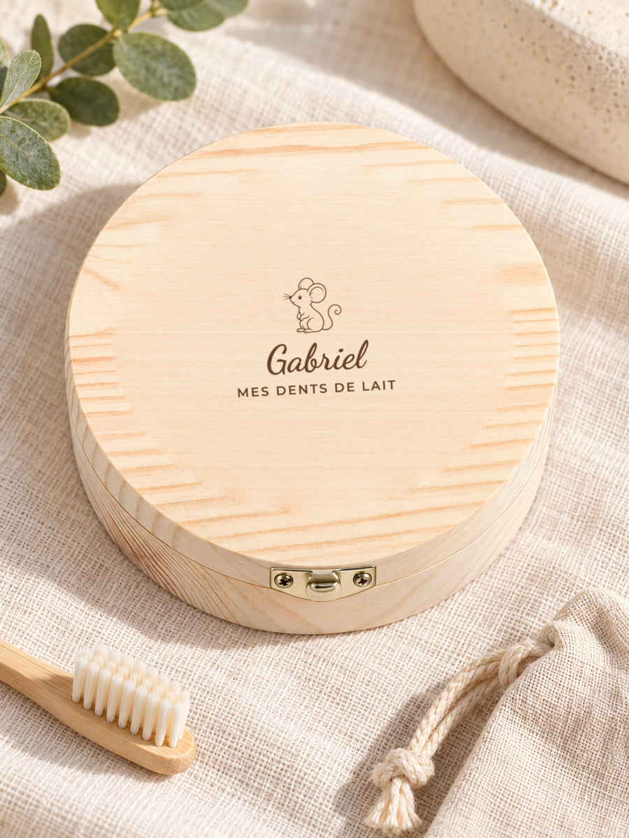 Visuel d’illustration – boîte en bois sur un lin près d’une petite brosse à dents, gravée « Gabriel » (exemple)