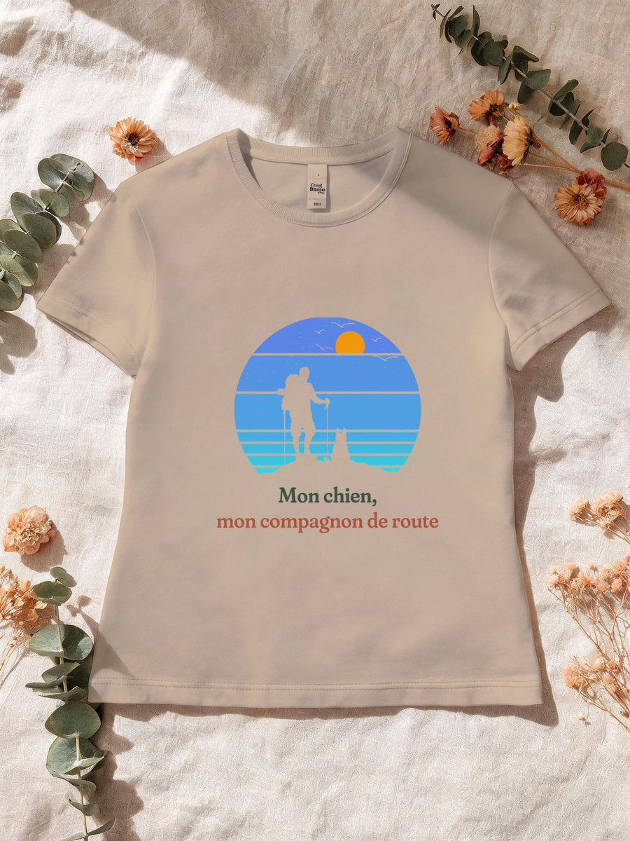 Visuel d’illustration – T-shirt femme sable avec le motif un randonneur et son chien sur une crête, en silhouettes devant un soleil couchant à bandes rétro bleues et « Mon chien, mon compagnon de route »