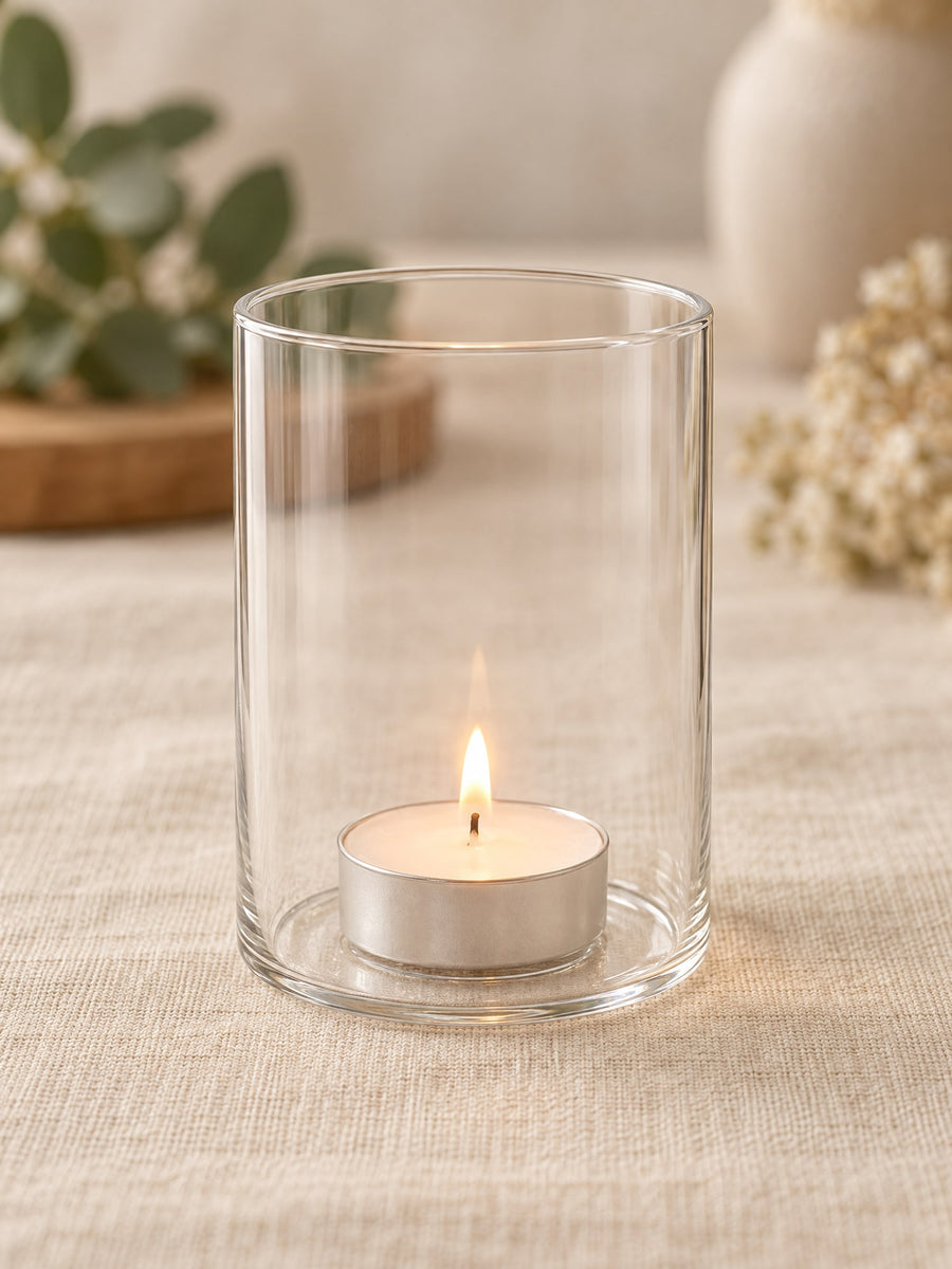 Visuel d’illustration – photophore cylindrique en verre transparent vierge avec une bougie chauffe-plat, sur un lin crème