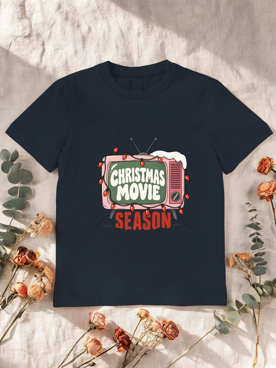 Visuel d’illustration – T-shirt enfant navy avec la télé rétro rose et sa guirlande, « Christmas Movie Season »