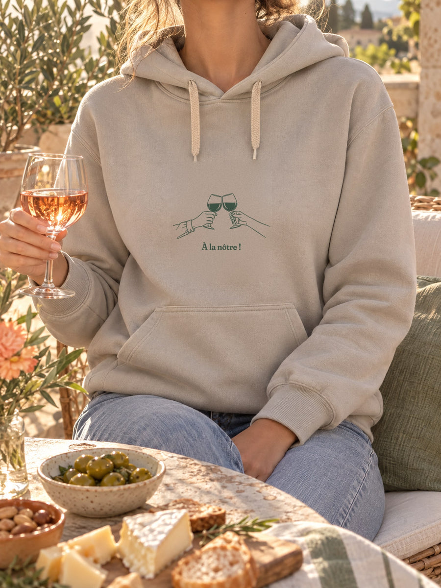 Visuel d’illustration – t-shirt dans une mise en situation, avec le motif deux mains qui trinquent avec deux verres de vin, au trait et « À la nôtre ! »