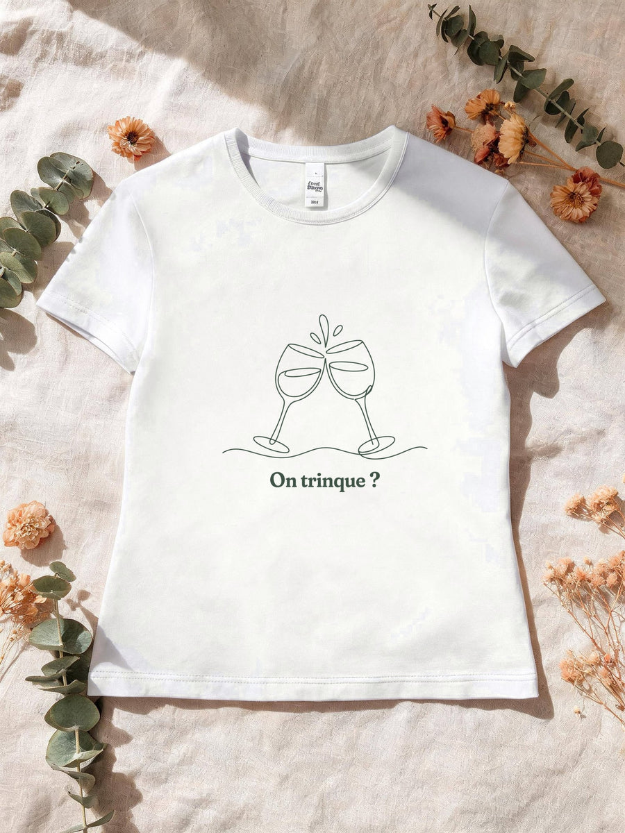 Visuel d’illustration – T-shirt femme blanc avec le motif deux verres à vin qui trinquent, dessinés d’un seul trait continu et « On trinque ? »