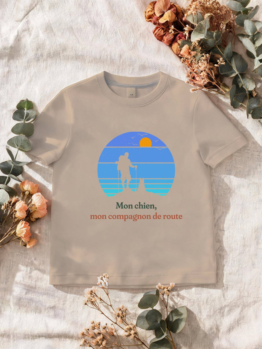 Visuel d’illustration – T-shirt homme sable avec le motif un randonneur et son chien sur une crête, en silhouettes devant un soleil couchant à bandes rétro bleues et « Mon chien, mon compagnon de route »