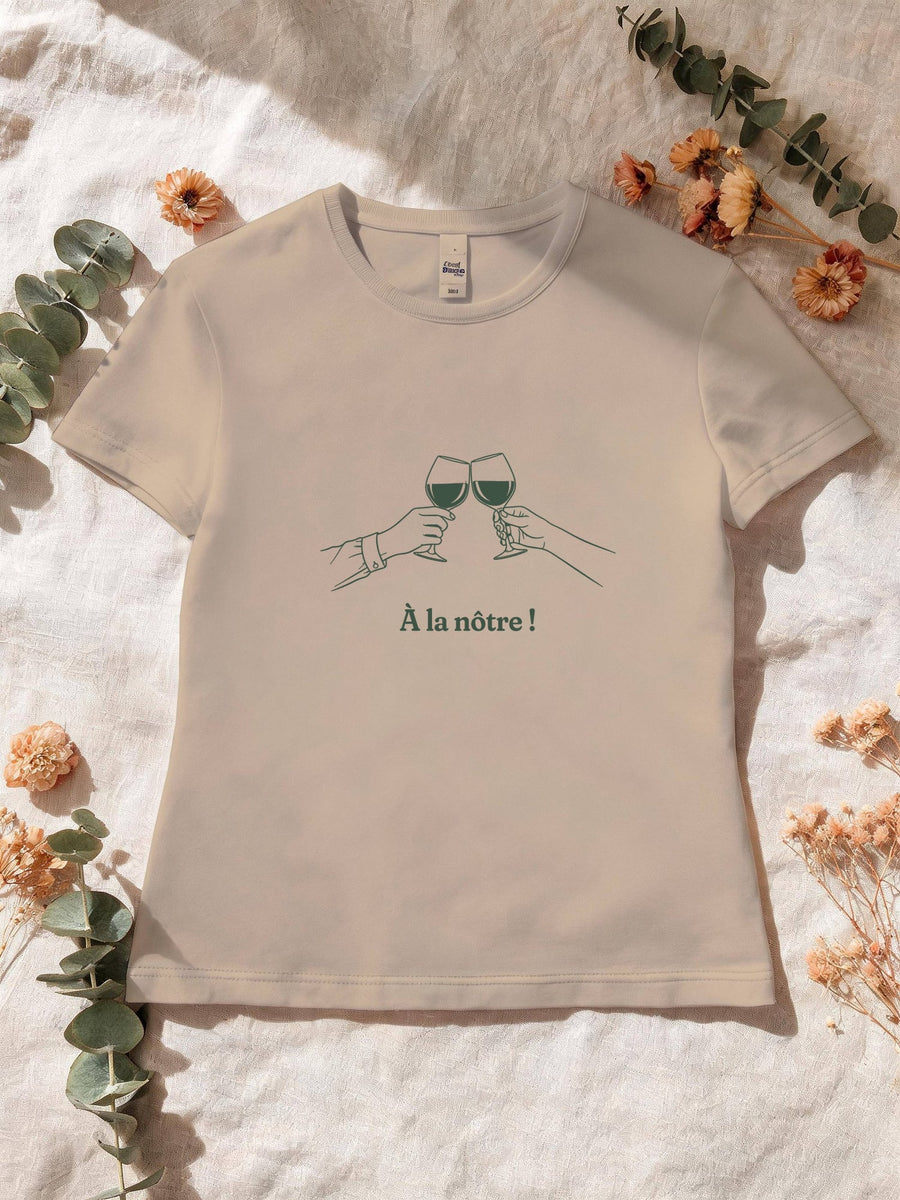 Visuel d’illustration – T-shirt femme sable avec le motif deux mains qui trinquent avec deux verres de vin, au trait et « À la nôtre ! »