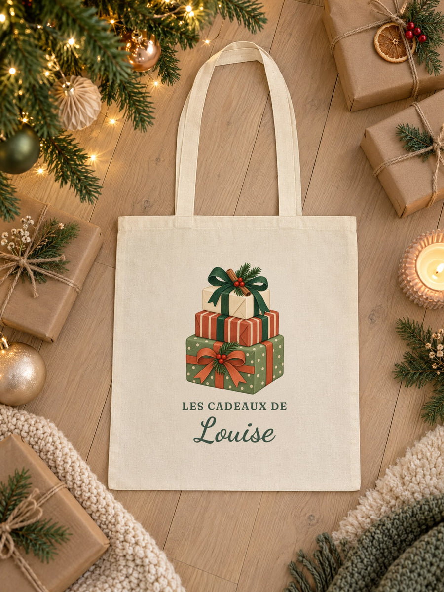Visuel d’illustration – tote bag « Les cadeaux de Louise » posé à plat au pied du sapin, entre des paquets cadeaux