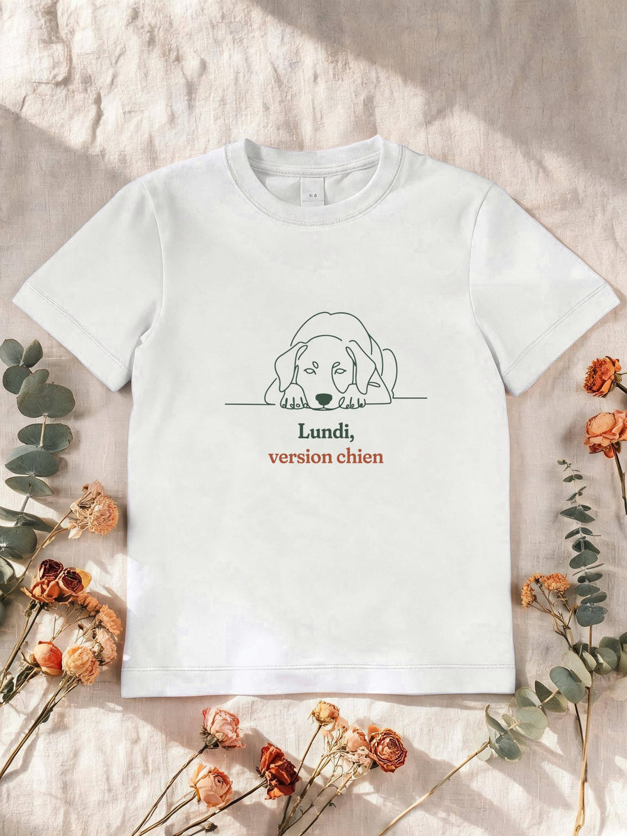 Visuel d’illustration – T-shirt enfant blanc avec le motif un chien allongé, la tête posée sur les pattes, l’air de bouder, dessiné d’un seul trait continu et « Lundi, version chien »