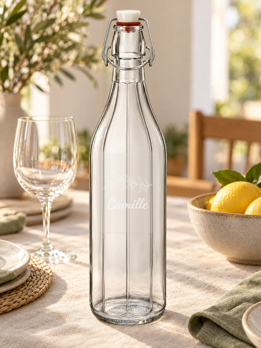 Visuel d’illustration – bouteille gravée d’un rameau d’olivier et « Camille » (exemple) sur une table dressée