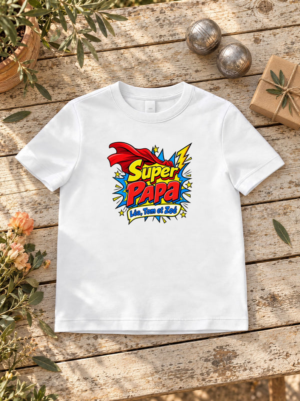 Visuel d’illustration – T-shirt homme blanc avec le design « Super Papa », posé à plat sur une table de jardin, avec les prénoms d’exemple 