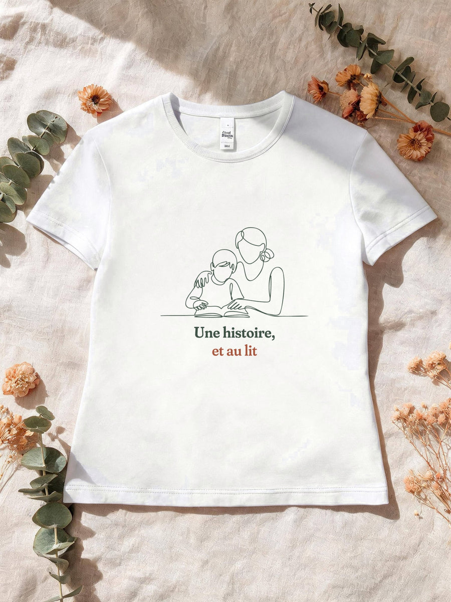 Visuel d’illustration – T-shirt femme blanc avec le motif une maman qui lit une histoire à son enfant, dessinée d’un seul trait continu et « Une histoire, et au lit »