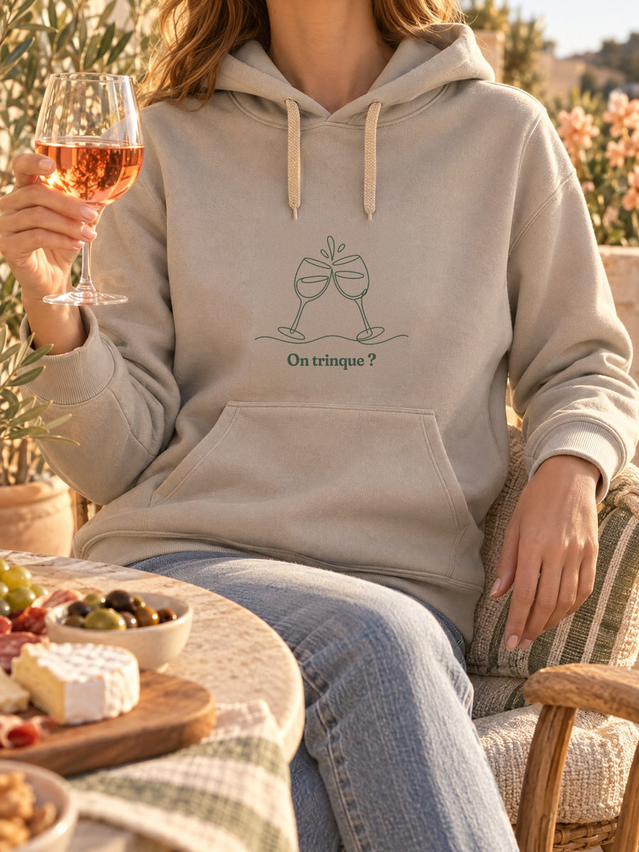Visuel d’illustration – t-shirt dans une mise en situation, avec le motif deux verres à vin qui trinquent, dessinés d’un seul trait continu et « On trinque ? »