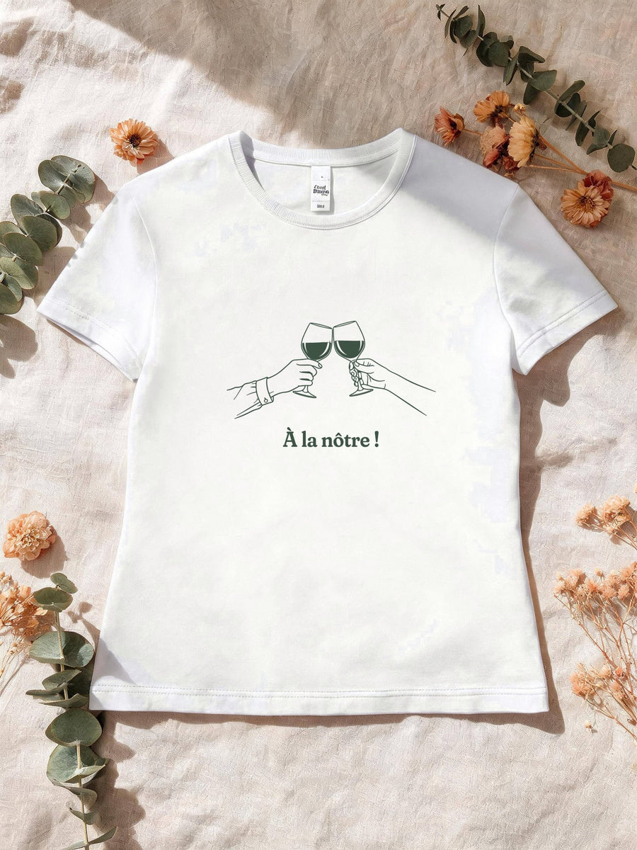 Visuel d’illustration – T-shirt femme blanc avec le motif deux mains qui trinquent avec deux verres de vin, au trait et « À la nôtre ! »