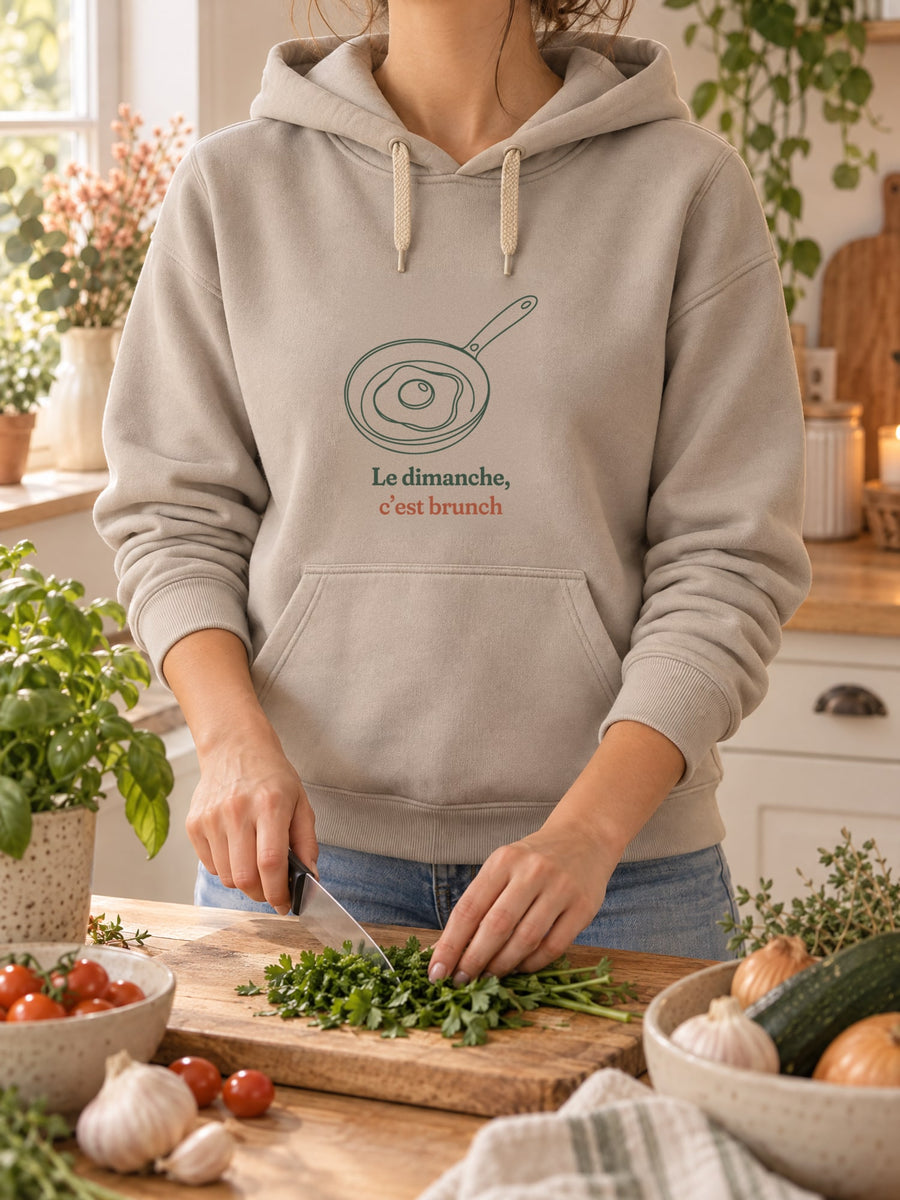 Visuel d’illustration – t-shirt dans une mise en situation, avec le motif un œuf au plat dans une poêle, dessiné d’un seul trait continu et « Le dimanche, c’est brunch »
