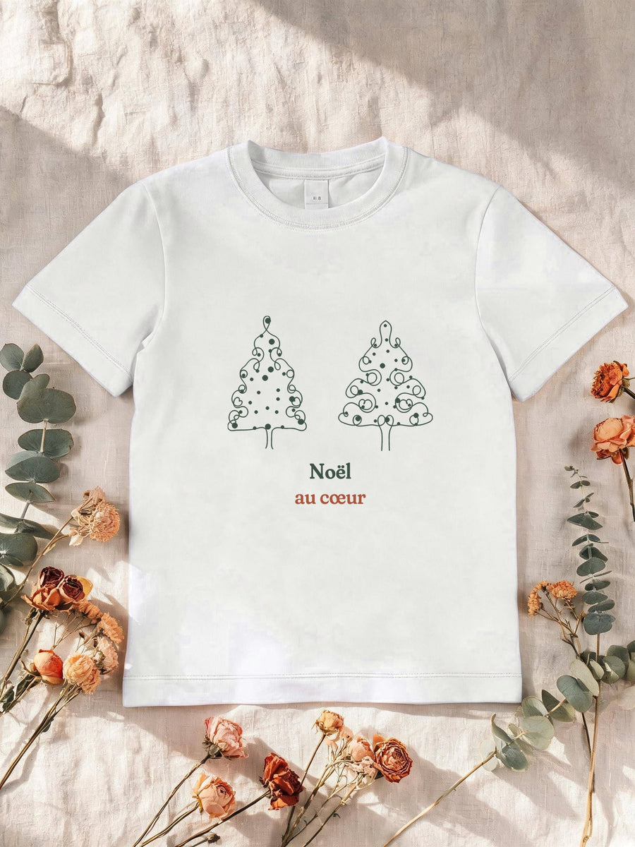 Visuel d’illustration – T-shirt enfant blanc avec le motif deux sapins de Noël dessinés d’un seul trait, décorés de boules rouges et « Noël au cœur »
