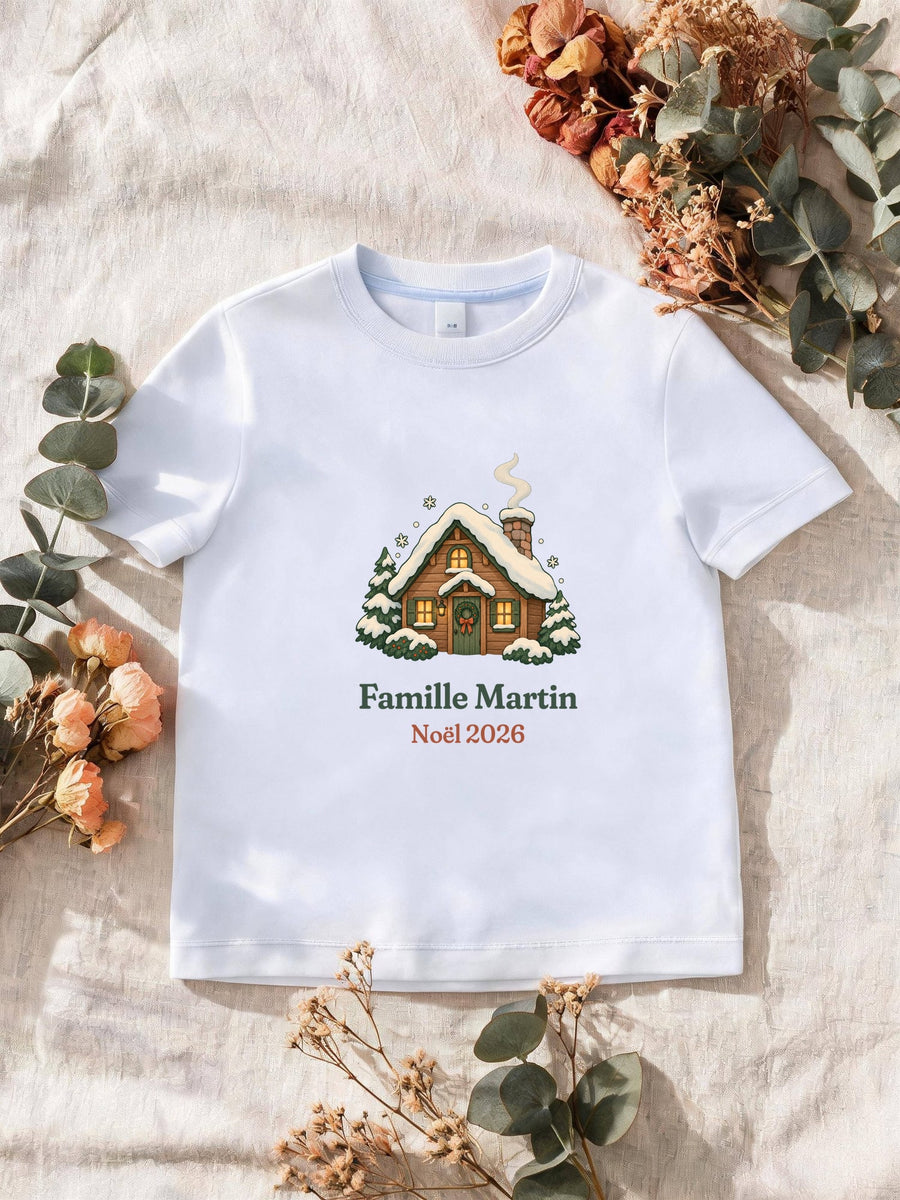 Visuel d’illustration – T-shirt homme blanc avec le motif un chalet sous la neige et « Famille Martin · Noël 2026 » (exemple de nom)