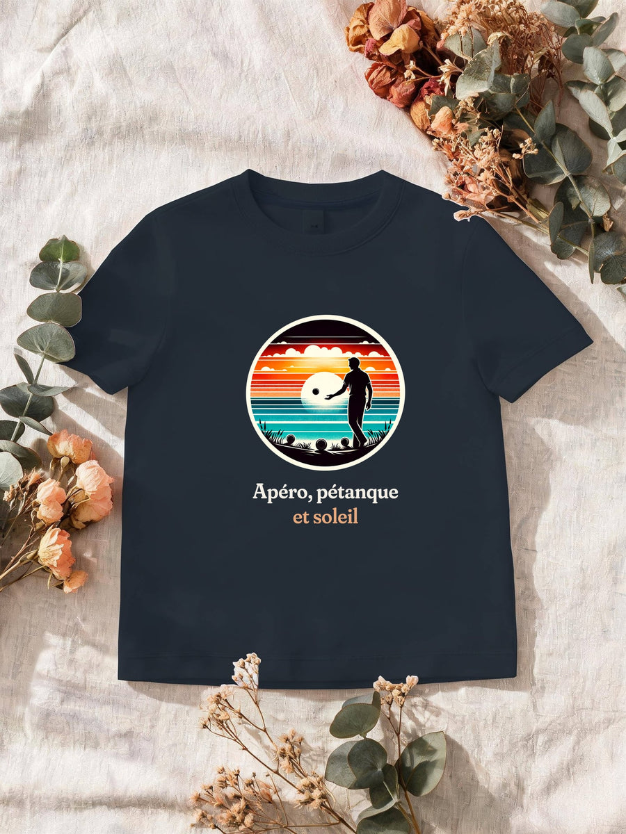 Visuel d’illustration – T-shirt homme navy avec le motif un joueur de pétanque, boules au sol, en silhouette devant un coucher de soleil sur la mer, dans un médaillon rond et « Apéro, pétanque et soleil »