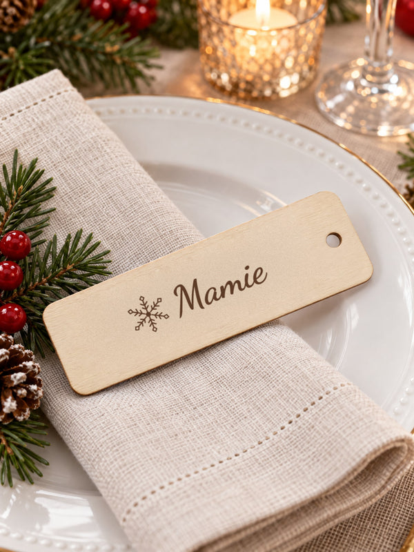 Visuel d’illustration – marque-place en bois gravé d’un flocon et de « Mamie » (exemple) posé sur une assiette de fête