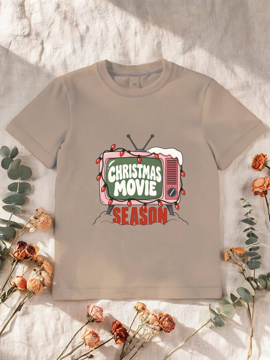 Visuel d’illustration – T-shirt enfant sable avec la télé rétro rose et sa guirlande, « Christmas Movie Season »