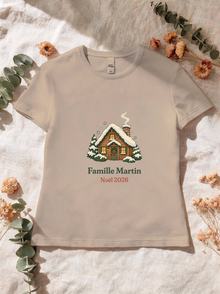 Visuel d’illustration – T-shirt femme sable avec le motif un chalet sous la neige et « Famille Martin · Noël 2026 » (exemple de nom)